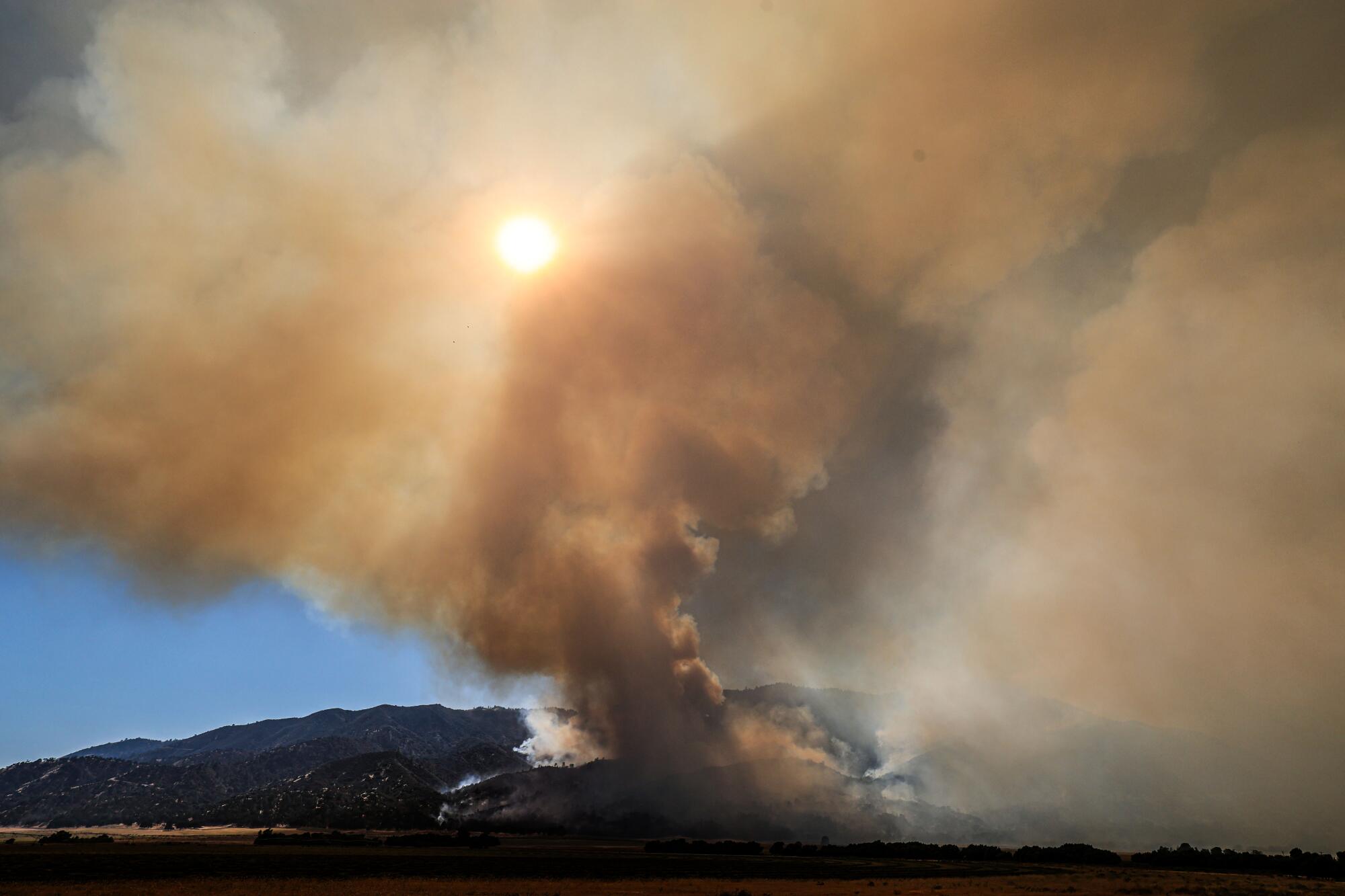 Breckenridge Mountain is obscured by smoke from the southeastern flank of the Borel fire near the community of Twin Oaks.