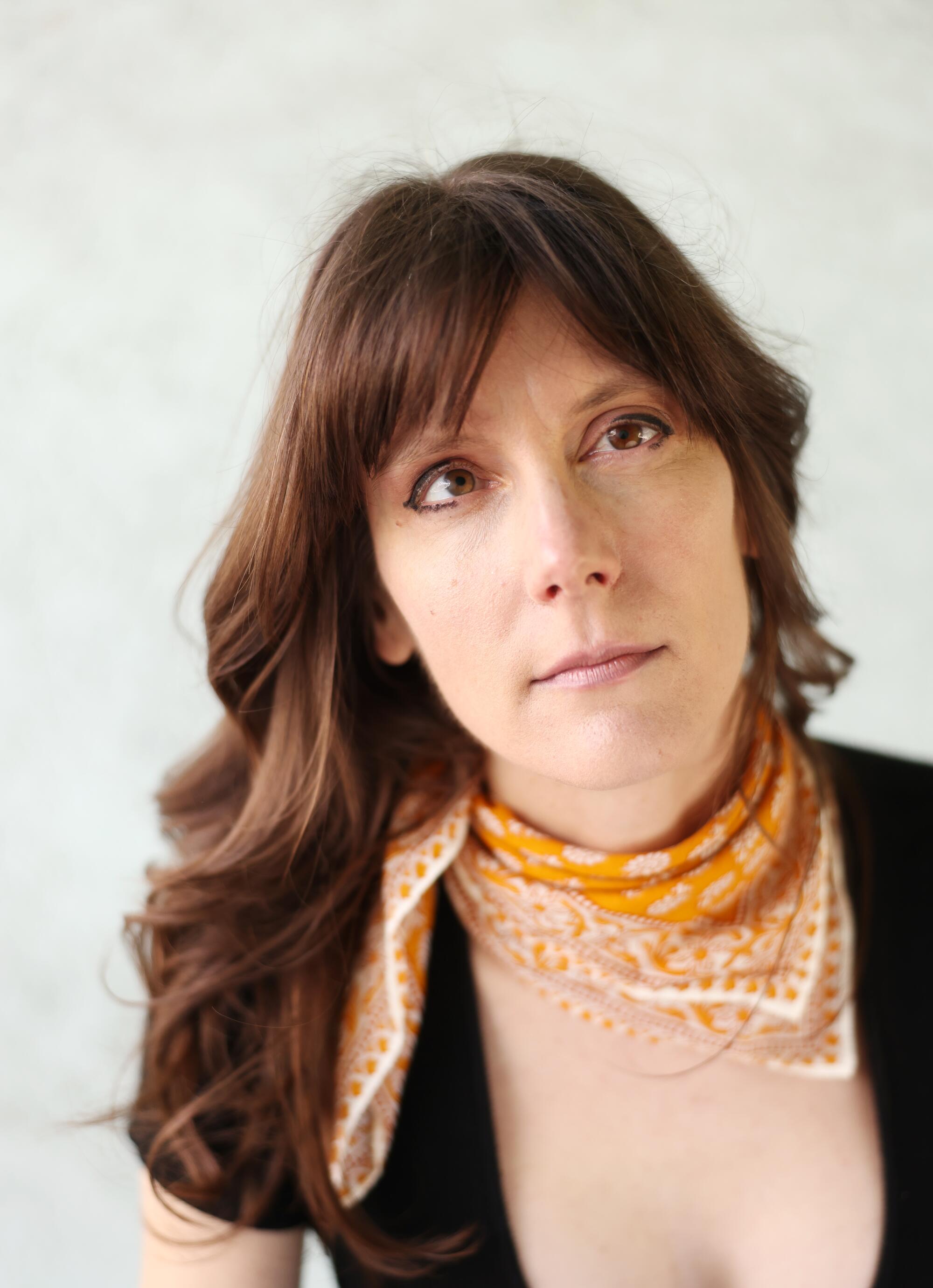 A portrait of Ayla Harrison in an orange scarf.