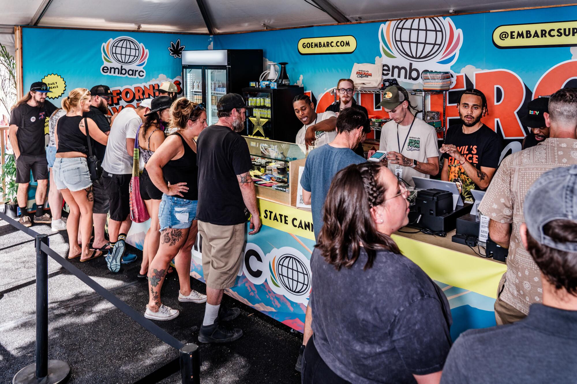 people in line at a tented dispensary space