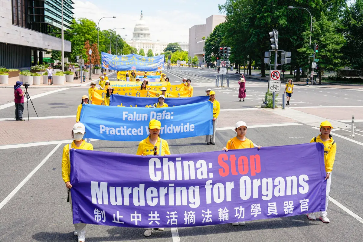 Falun Gong adherents march during a parade calling for the end of the Chinese Communist Party’s 25 years of ongoing persecution of Falun Gong practitioners in China at the National Mall in Washington on July 11, 2024. (Larry Dye/The Epoch Times)