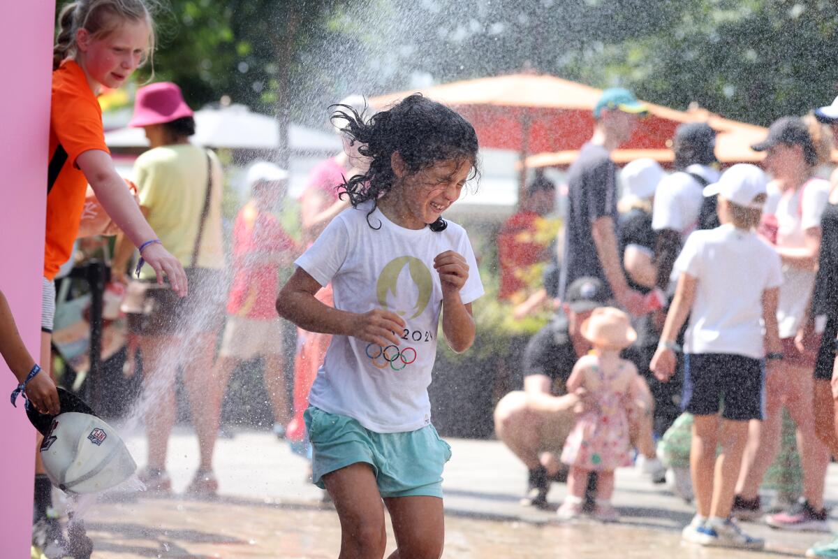 A child walks through a mister at Roland Garros in Paris on Wednesday.