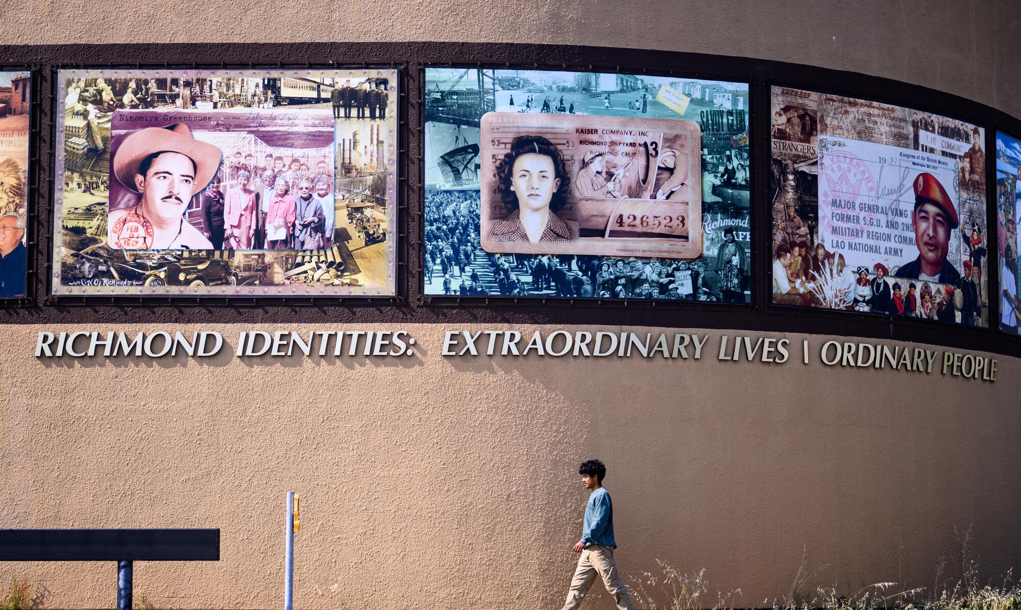 A boy walks by murals celebrating Richmond's history. 