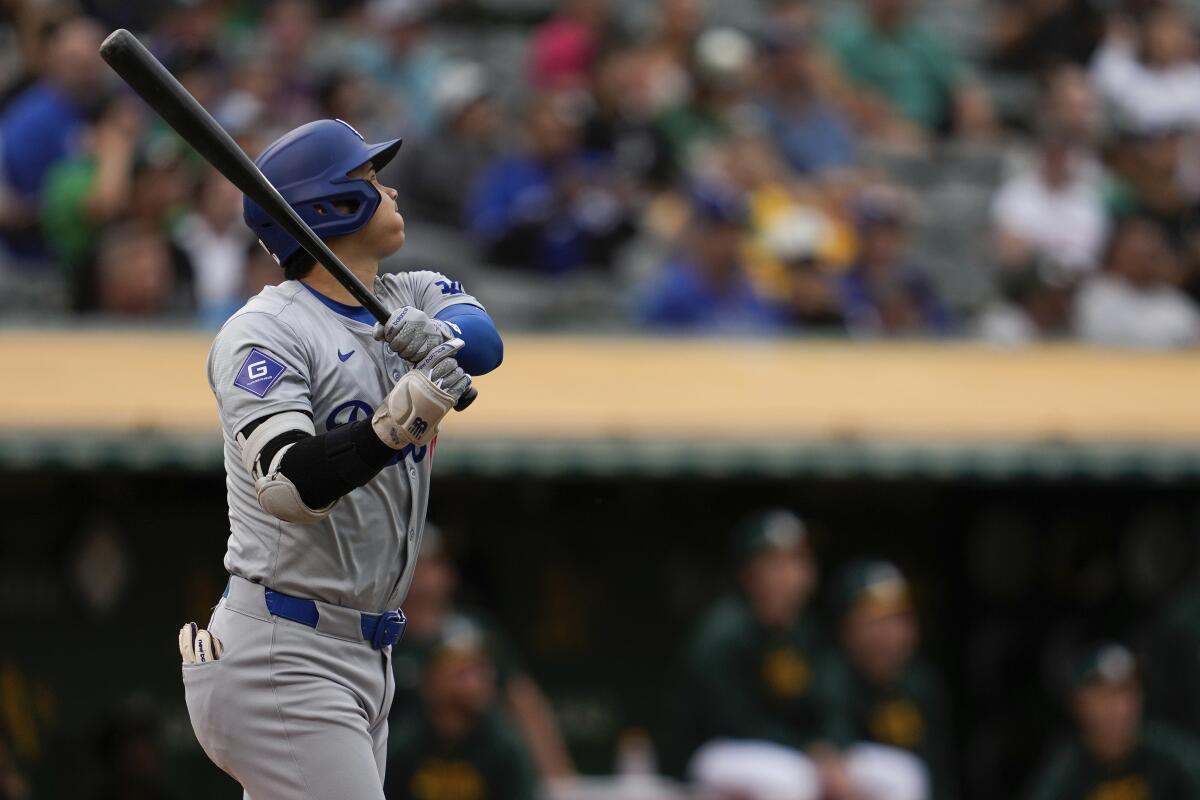 The Dodgers' Shohei Ohtani watches Oakland center fielder JJ Bleday catch his fly ball Friday