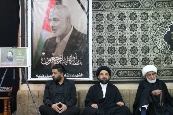 Iraqi and Iranian clerics and officials hold a vigil at the office of the representative of Iran's supreme leader in Iraq's Shiite holy city of Najaf, following the death of Hamas leader Ismail Haniyeh (portrait) and others killed in strikes in Lebanon and Iraq, on Aug. 1, 2024. (Qassem Al-Kaabi/AFP via Getty Images)