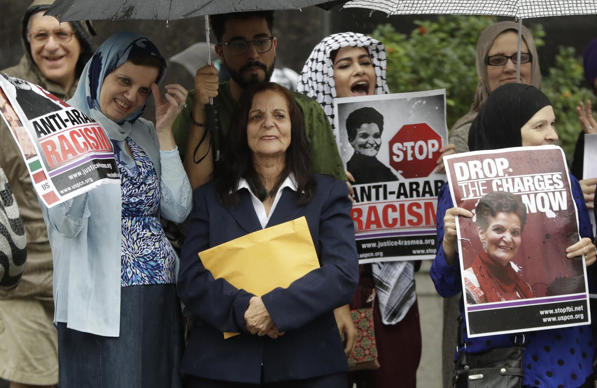 A woman stands among supportive demonstrators 