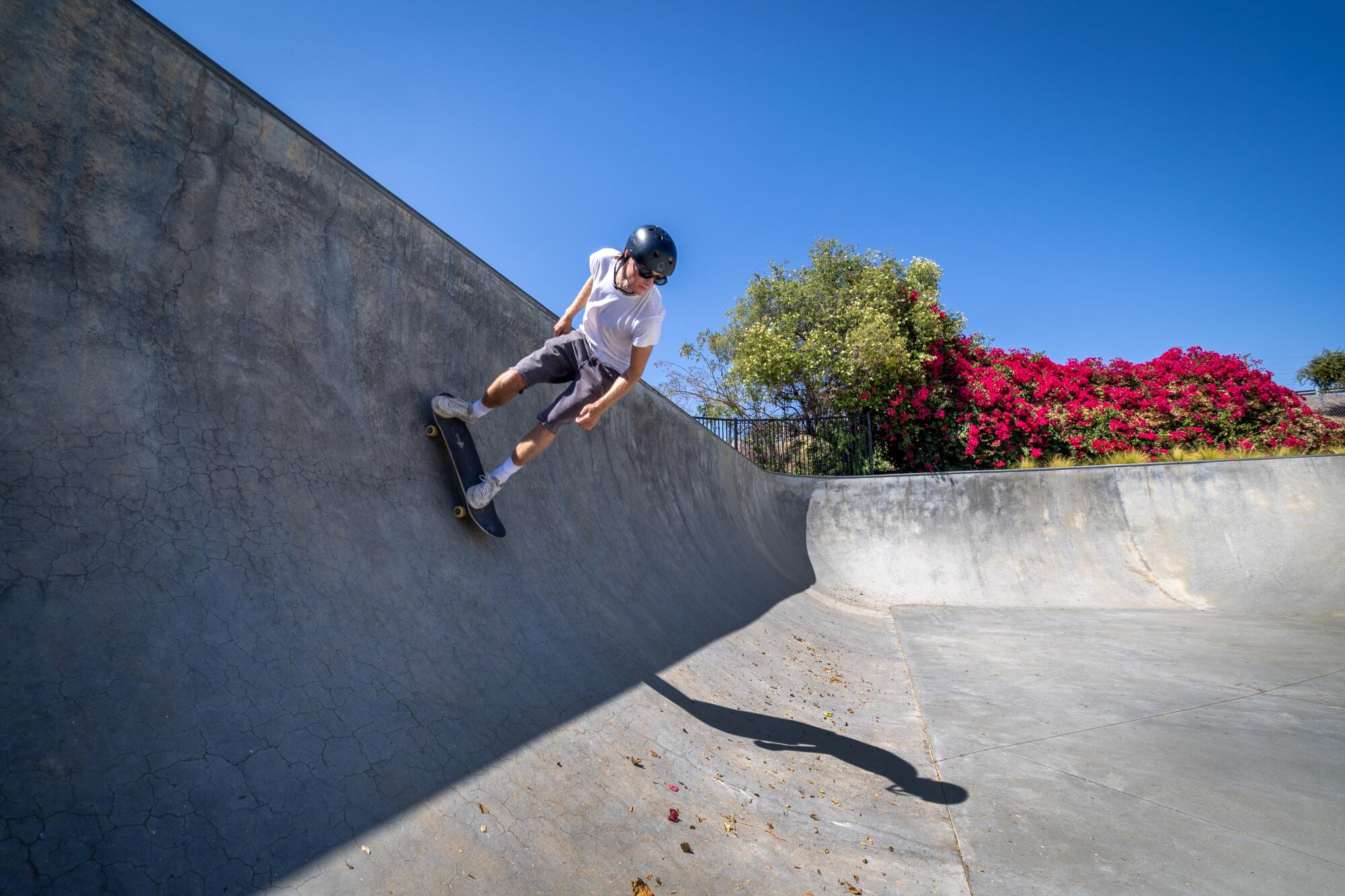 A skateboard descends a steep ramp.