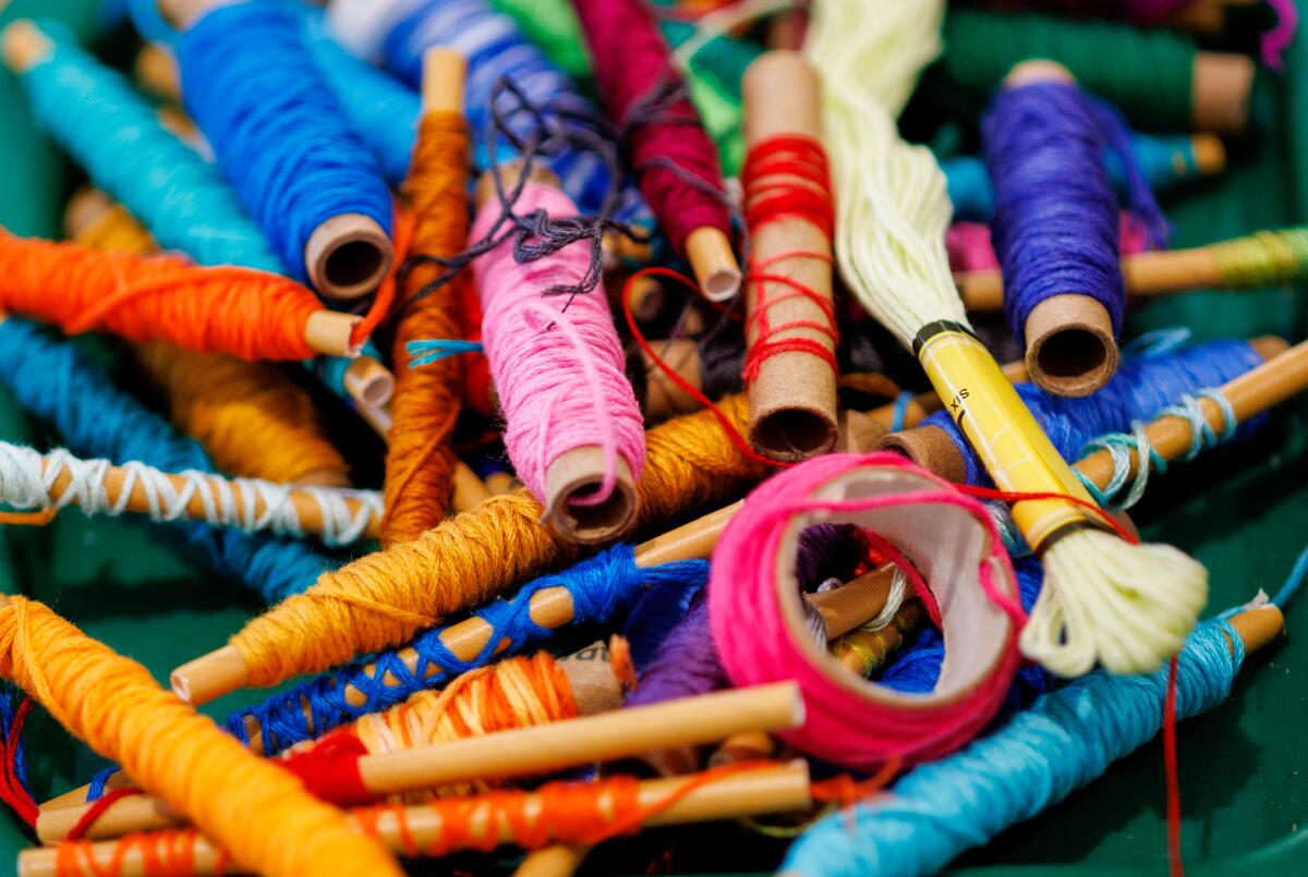 A pile of spools holding several different colors of thread.