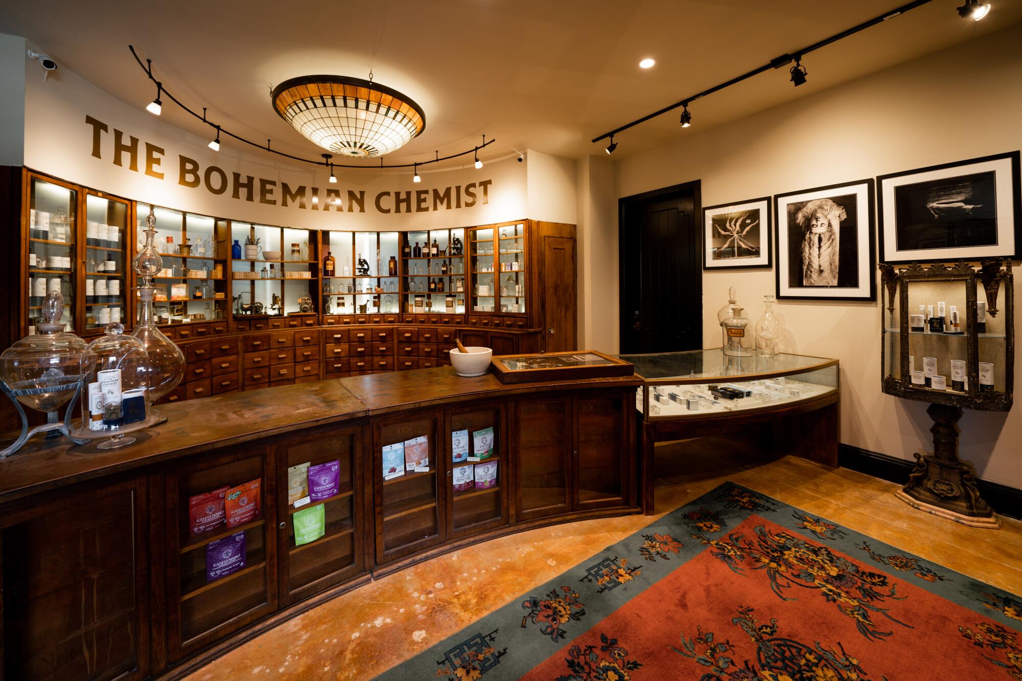 An old-timey-looking apothecary space with wood cabinets and glass shelves.