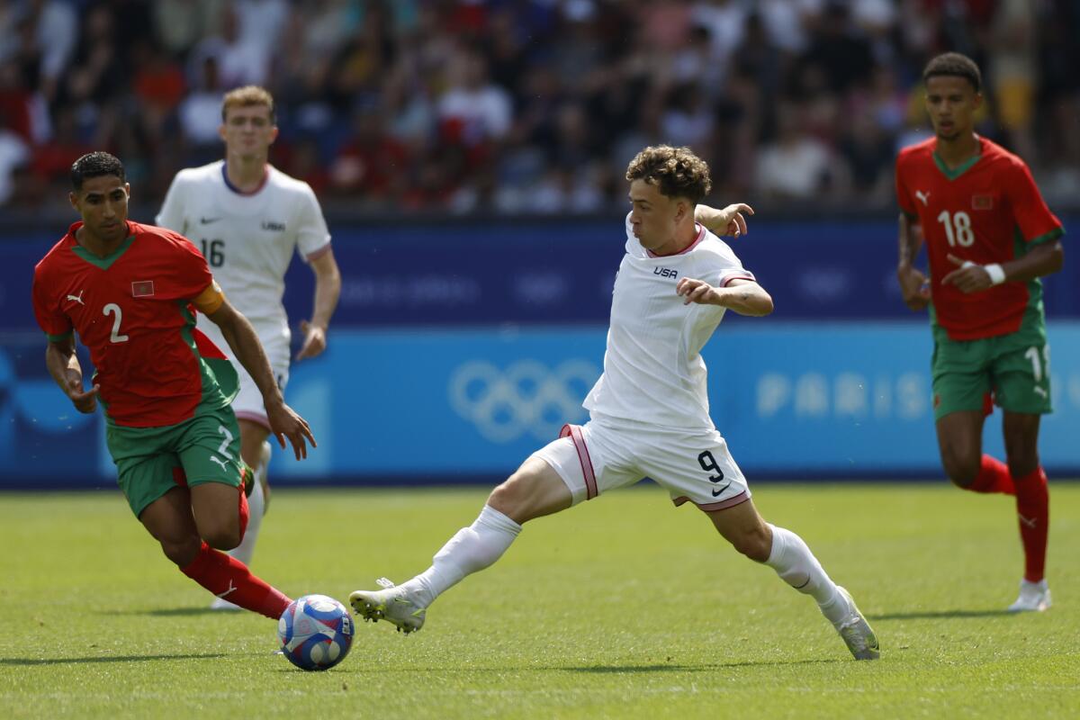 Morocco's Achraf Hakimi, left, challenges U.S. Griffin Yow during an Olympic quarterfinal match.