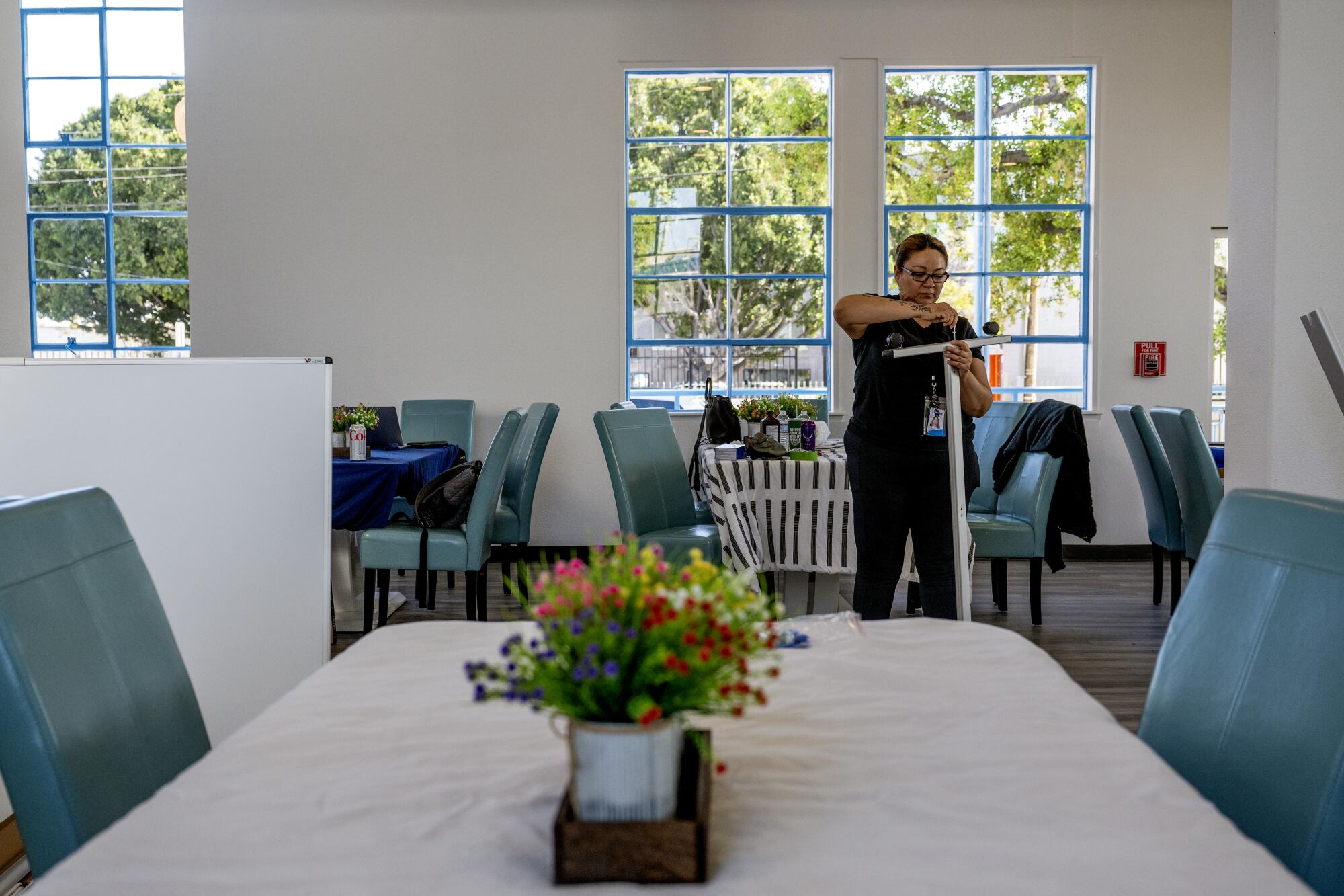 Case Manager Priscilla Nunez helps put together items in the dining area of the new Teen Project facility.