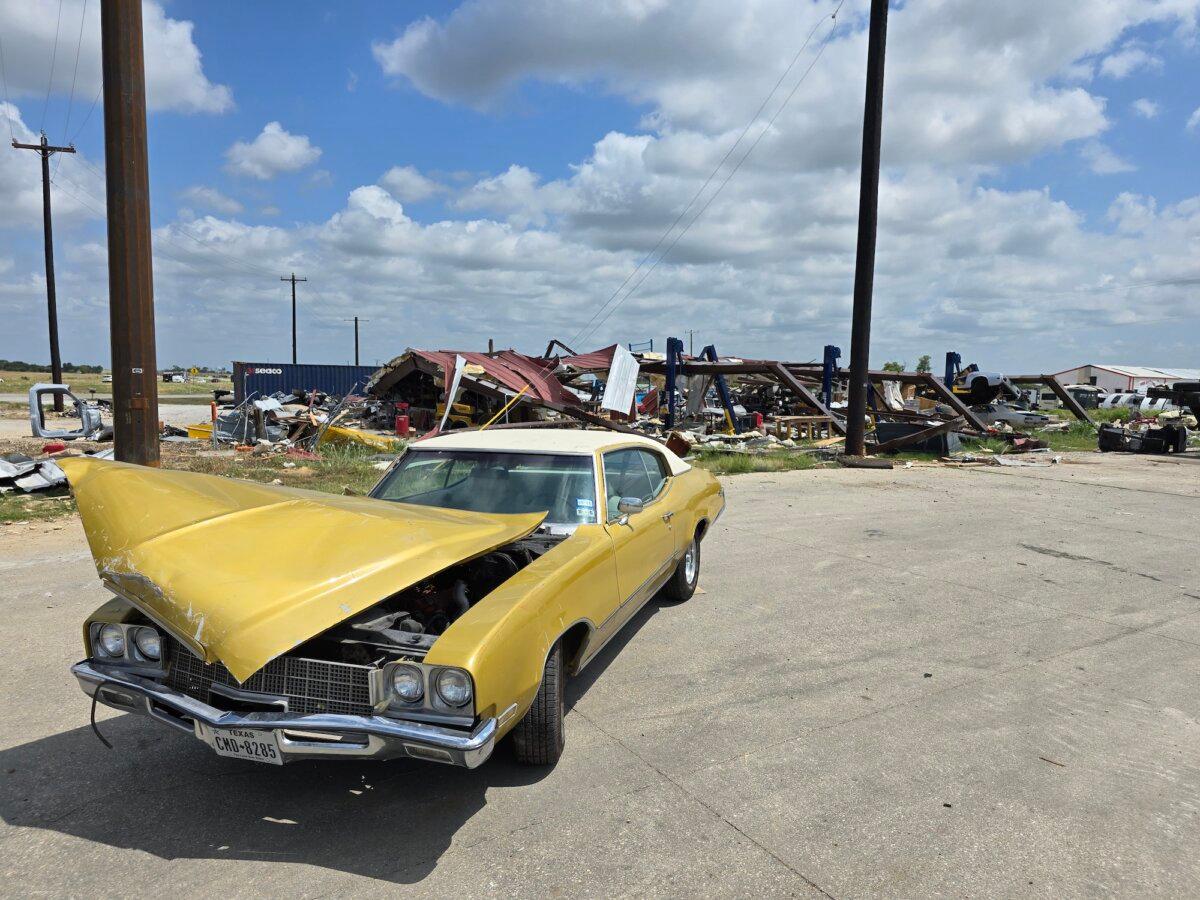 A vintage car with a mangled hood sits in the parking lot near a trailer park in Valley View, Texas, after surviving an EF-3 tornado on May 25, 2024. Photo taken on July 29, 2024. (Allan Stein/The Epoch Times)