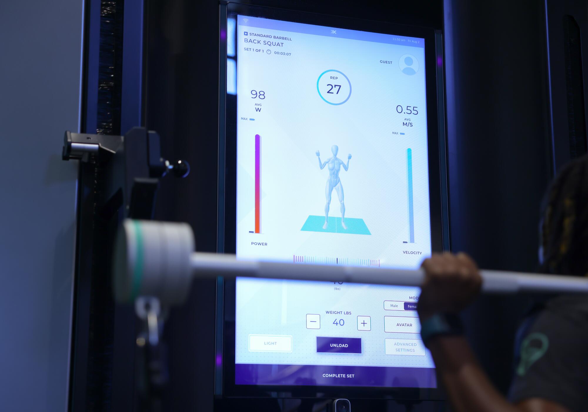 Love.Life personal trainer, Shelle Tarver, performs squats on a high tech OxeFit machine.