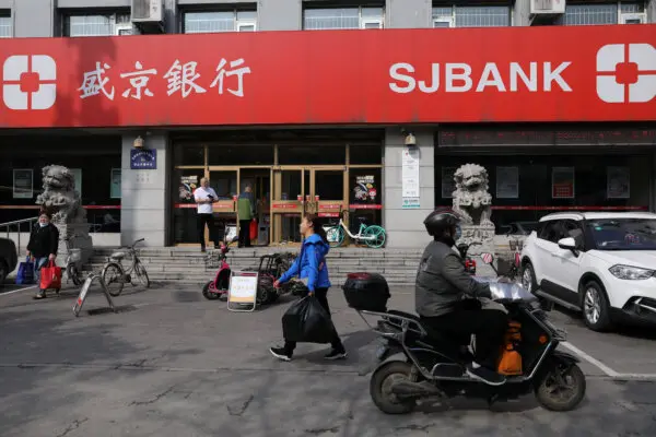 People walk past a branch of Shengjing Bank in Shenyang, Liaoning province, China, on Sept. 30, 2021. (Tingshu Wang/Reuters)