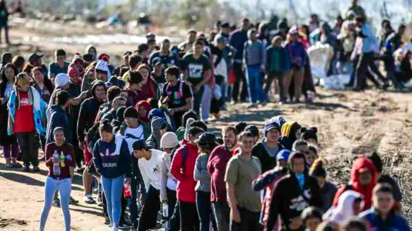 More than 1,000 illegal immigrants wait in line to be processed by U.S. Border Patrol agents after crossing the Rio Grande from Mexico in Eagle Pass, Texas, on Dec. 18, 2023. (John Moore/Getty Images)