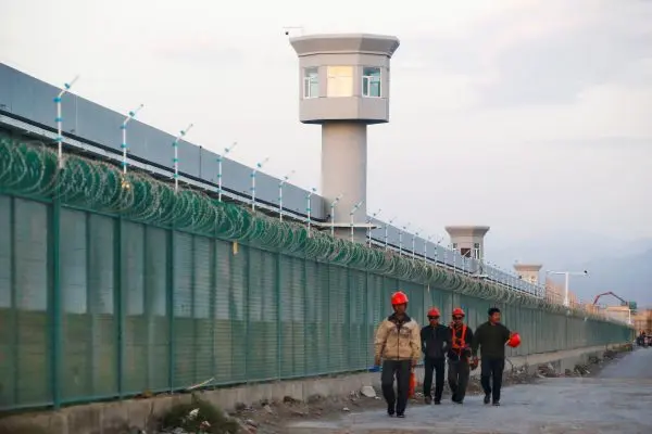 Workers walk by the perimeter fence of what is officially known as a vocational skills education center in Dabancheng in Xinjiang Uyghur Autonomous Region, China on Sept. 4, 2018. (Thomas Peter/Reuters)