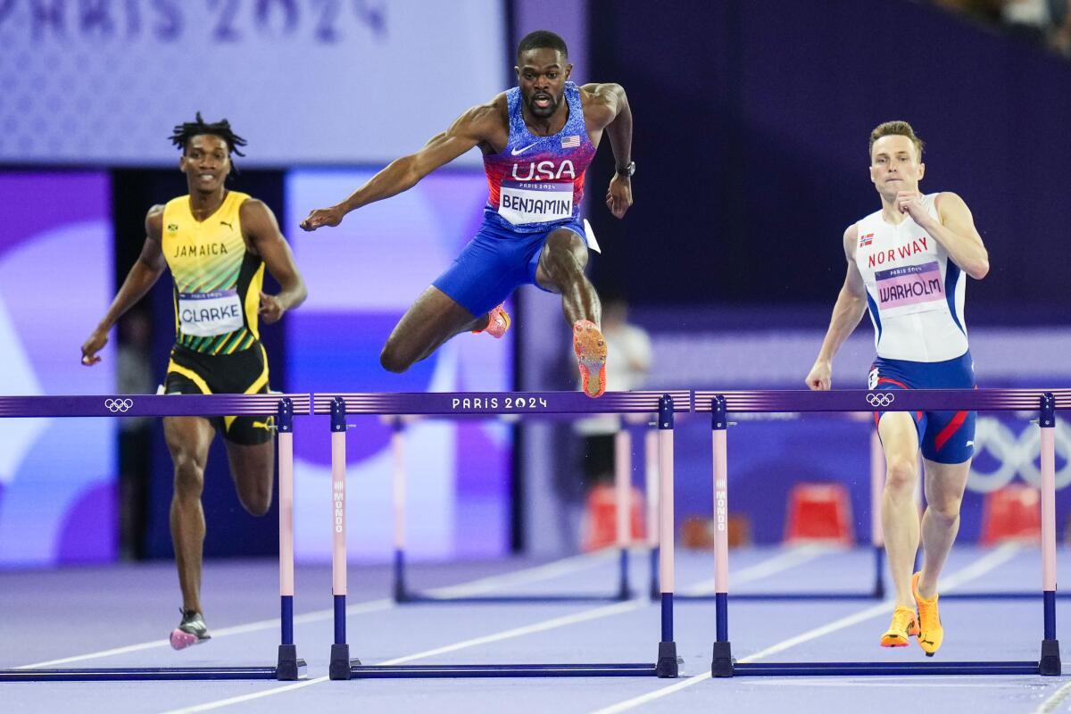 American Rai Benjamin jumps over a hurdle during a 4x100-meter hurdle during the 2024 Summer Olympics 