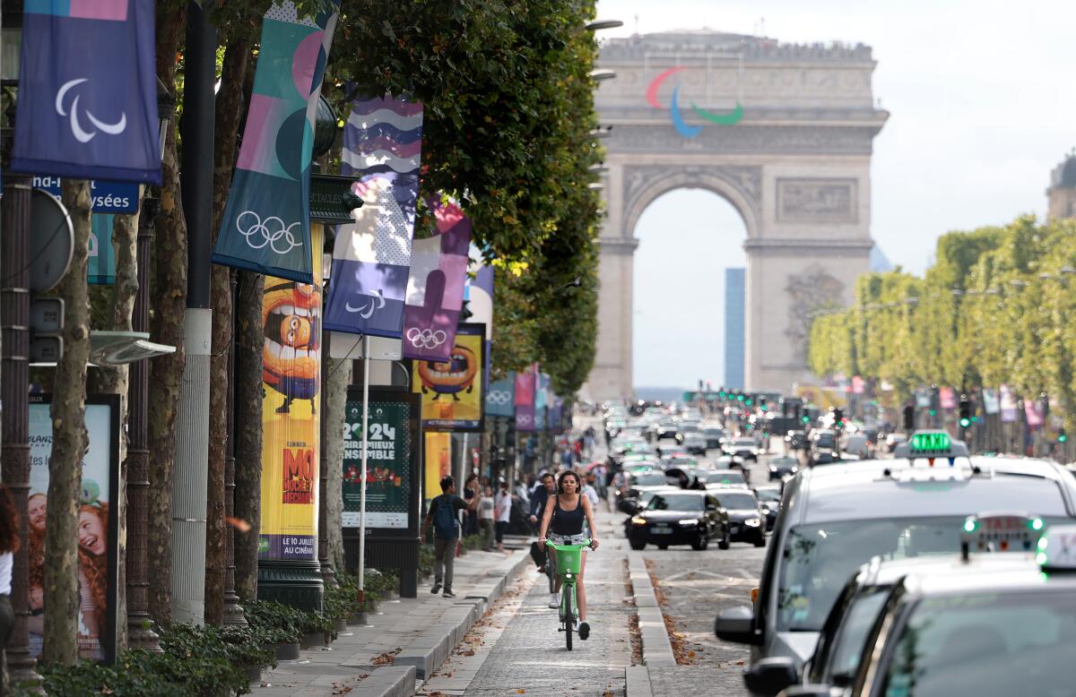 A woman rides along the Champ-Elysees before the Olympics in Paris on July 23.