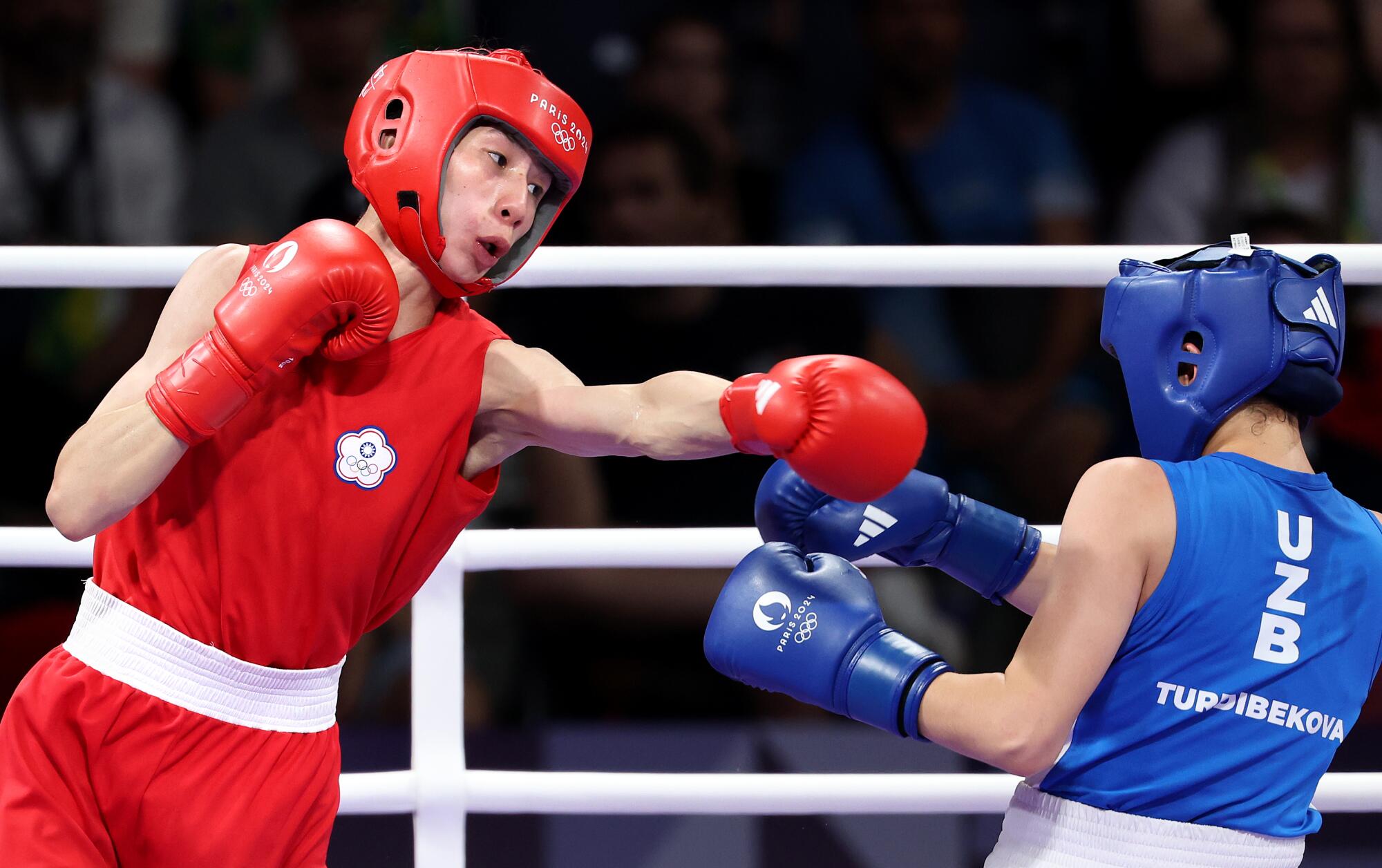 Uzebekistan's Sitora Turdibekova, blue, avoids a punch from Taipei's Yu Ting Lin in Paris, 