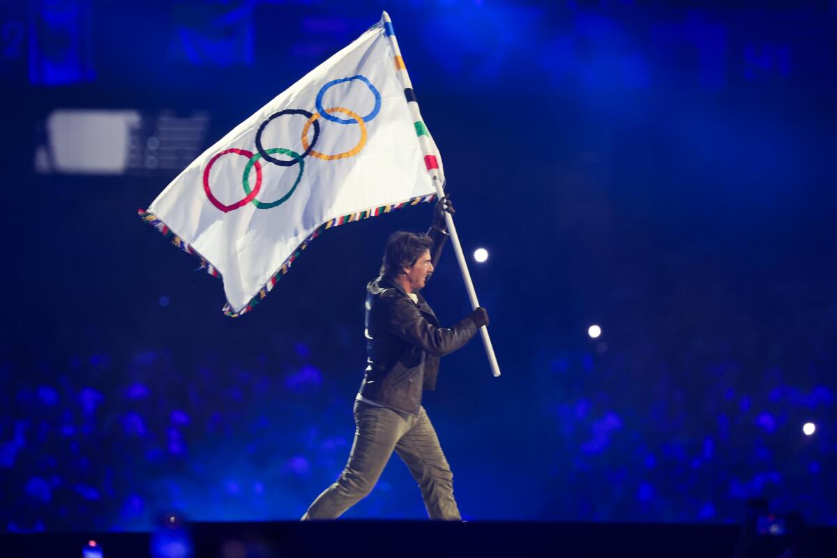 Tom Cruise carries the Olympic flag during the closing ceremony of the 2024 Paris Olympics at Stade de France on Sunday.