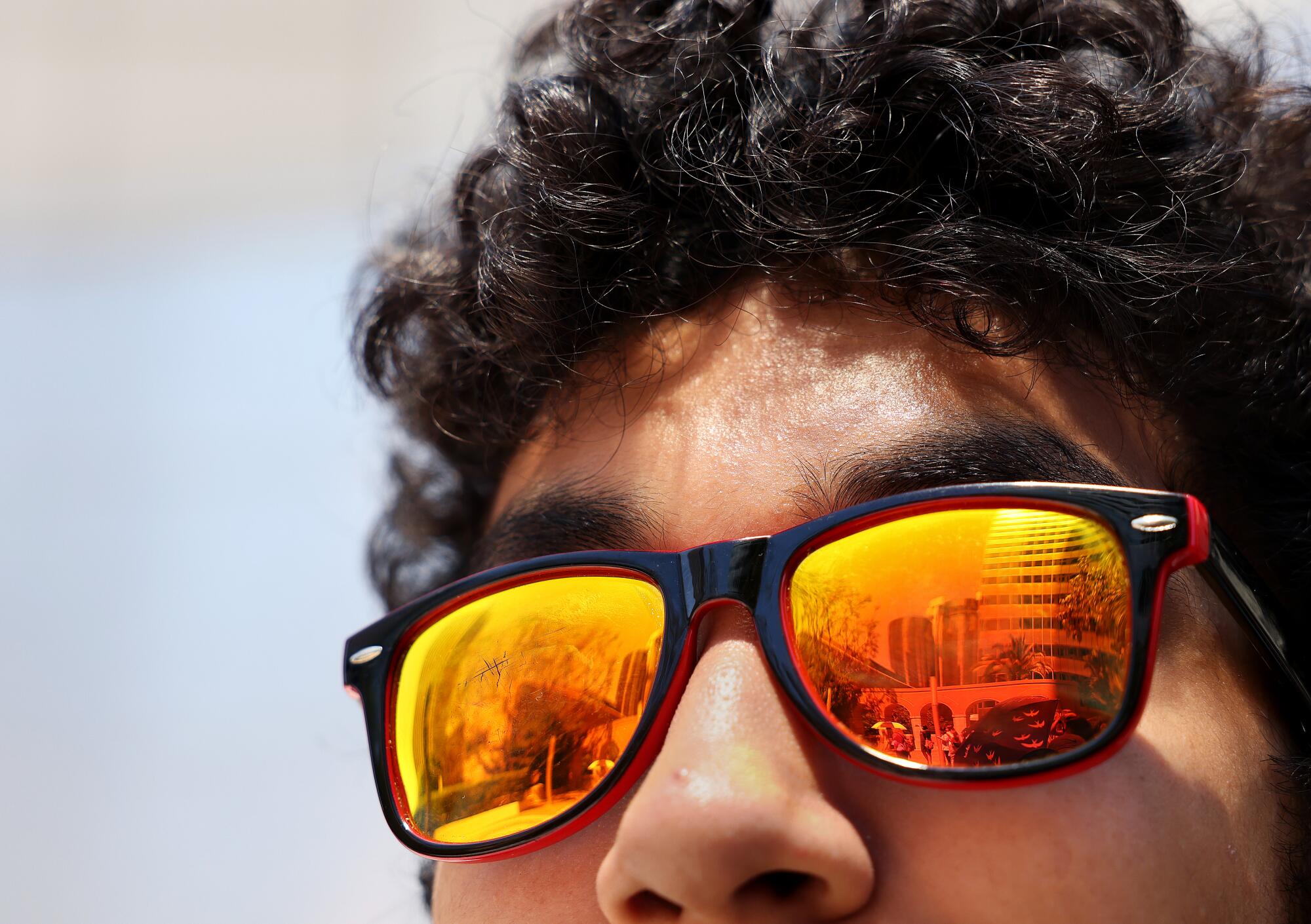 A teenage boy wears reflective sunglasses.