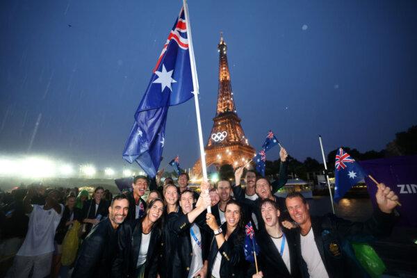 Jessica Fox and Eddie Ockenden, Flagbearers of Team Australia, poses for a photo with the illuminated Eiffel Tower while cruising on the River Seine during the athletes’ parade during the opening ceremony of the Olympic Games Paris 2024 on July 26, 2024. (Quinn Rooney/Getty Images)