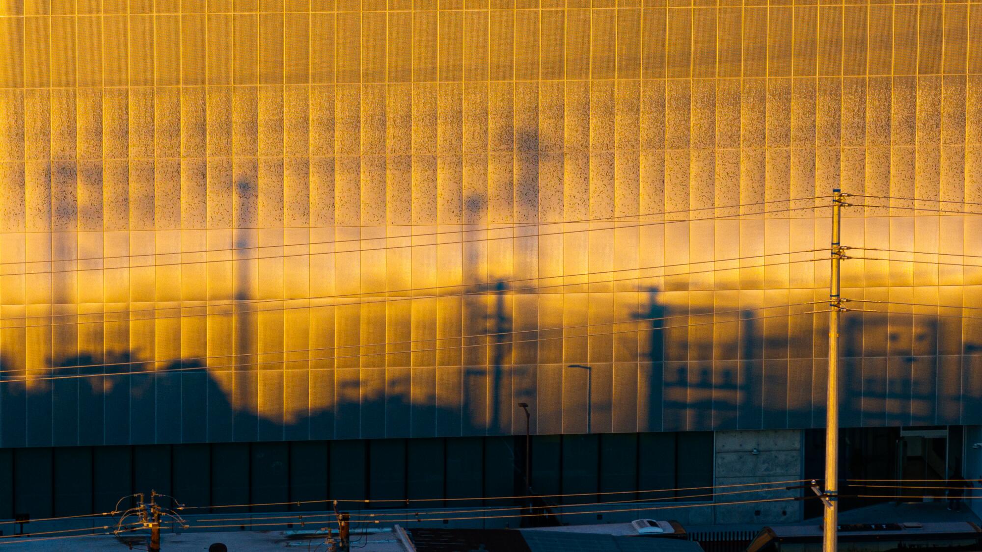 Transmission lines are reflected on the side of a building.