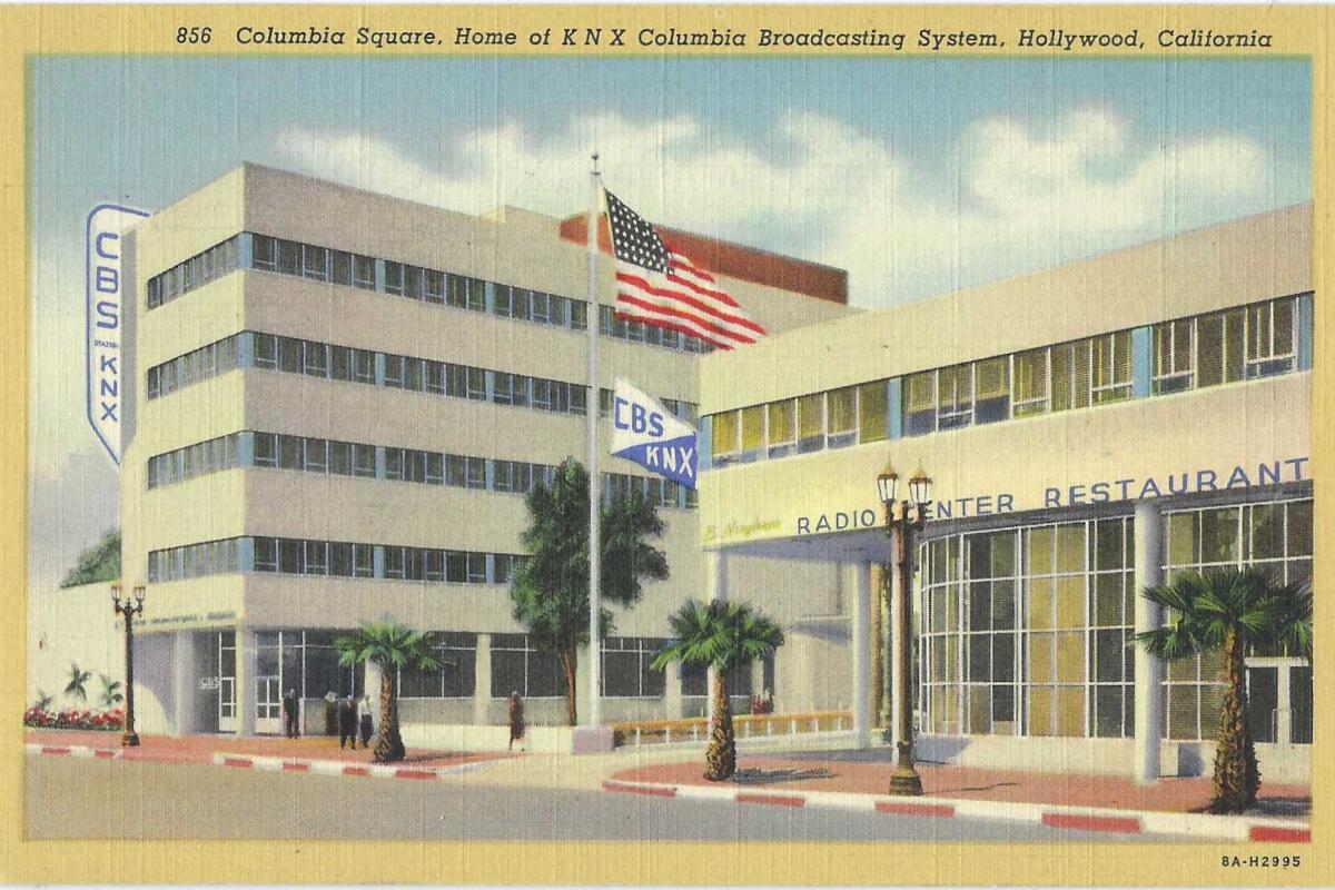 An American flag outside an office building. Signage: CBS, KNX, Radio Center Restaurant.