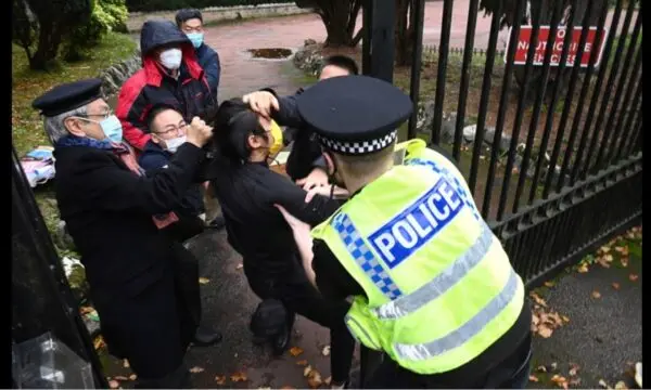 Consul General Zheng Xiyuan (L) and other Chinese diplomats drag pro-democracy protester Bob Chan into the Chinese Consulate while a police officer was trying to pull him out, in Manchester, United Kingdom, on Oct. 16, 2022. (Hong Kong Indigenous Defense Force / Used by permission)