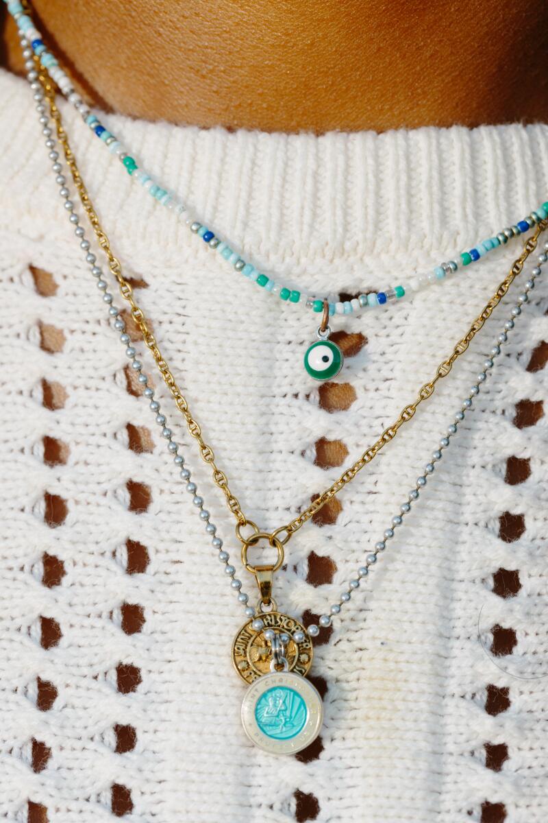 A closeup of three layered necklaces, two turquoise and one gold.