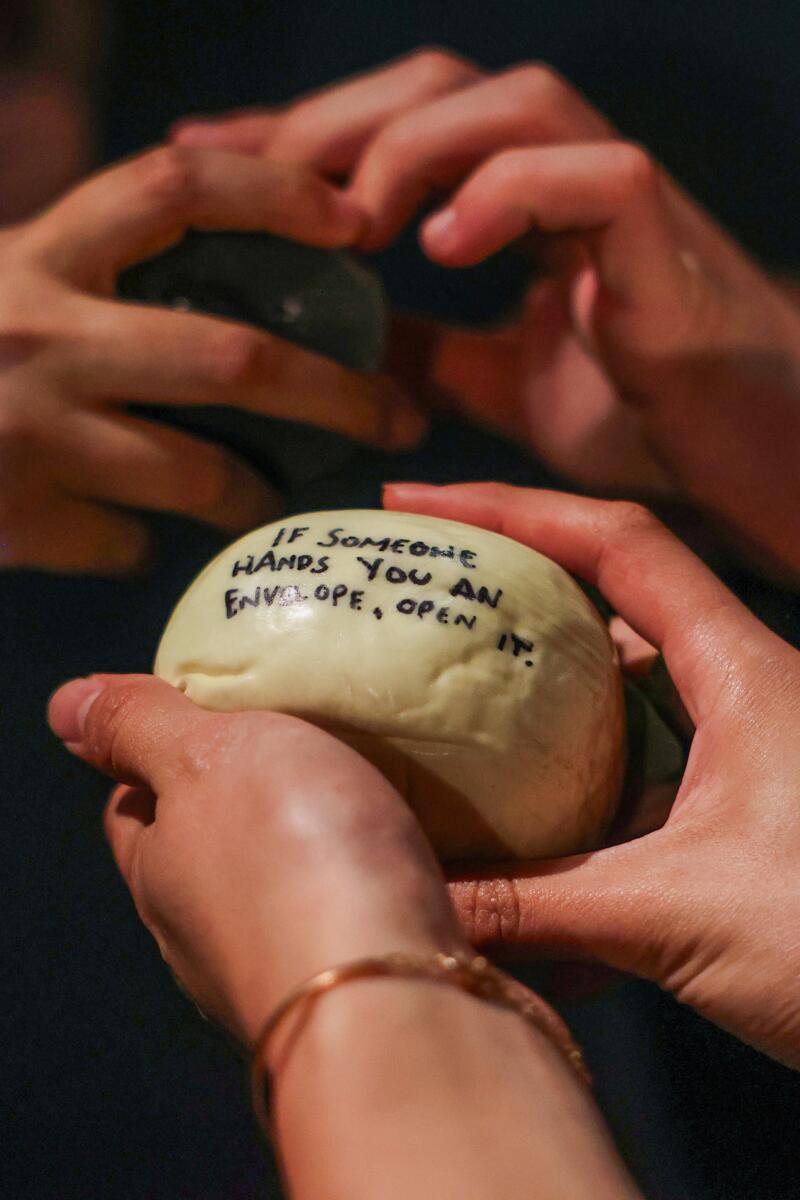 Melanie Pentecost holds a rock that gives the next context clue to to move the play forward.