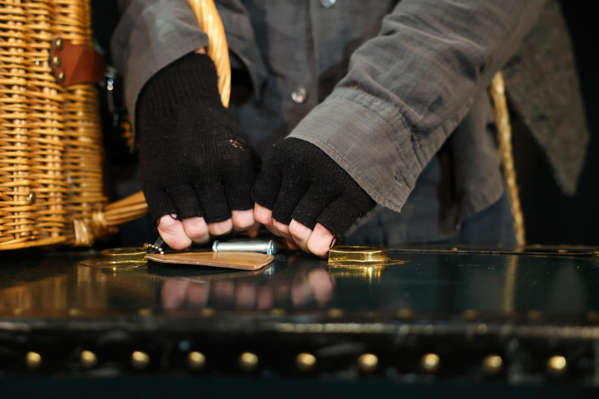 Actor Mason Conrad holds a large suitcase while performing in "Escape from Godot."