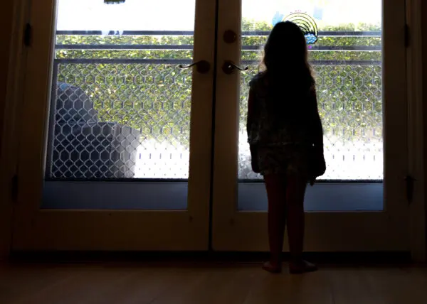 Becca, age 5, who has been diagnosed with Alice in Wonderland Syndrome, looks out her window in the Los Angeles area in California on Aug. 13, 2024. (John Fredricks/The Epoch Times)